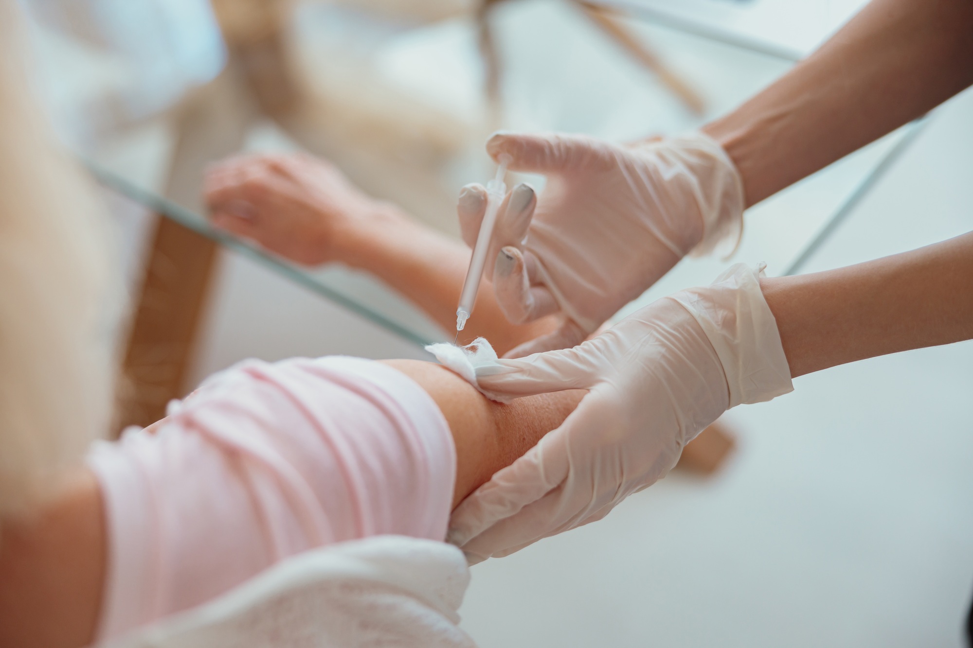 Nurse giving injection to senior woman in living room
